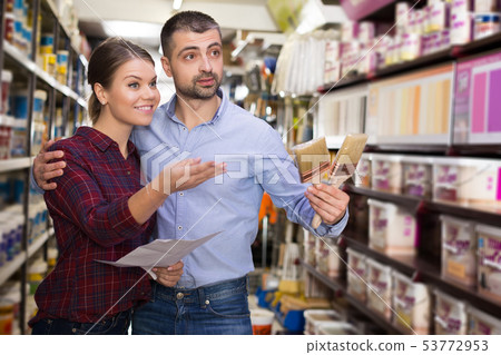couple is choosing color for paint with brushes couple is choosing color for paint with brushes 53772953
