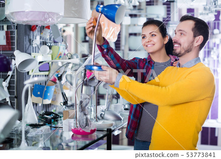 Man and girl choose table lamp 53773841