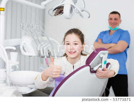 Girl patient in dental office showing ok gesture Girl patient in dental office showing ok gesture 53773871