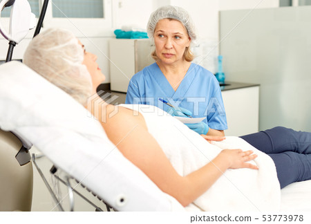 Doctor beautician polls a patient at the clinic Doctor beautician polls a patient at the clinic 53773978