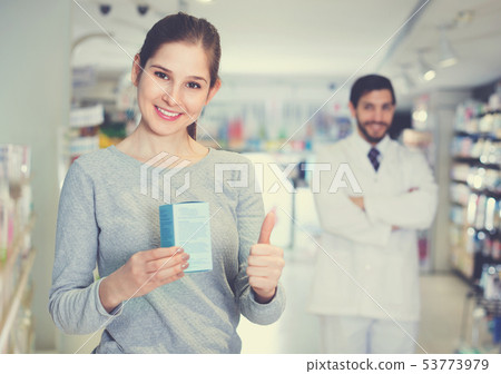 Smiling female client is satisfied of recommended medicine in apothecary. Smiling female client is satisfied of recommended medicine in apothecary. 53773979