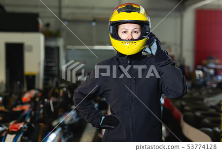 Glad woman in helmet standing near sport cars Glad woman in helmet standing near sport cars 53774128