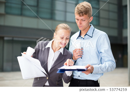 Couple enterpreneurs are examining documents Couple enterpreneurs are examining documents 53774259