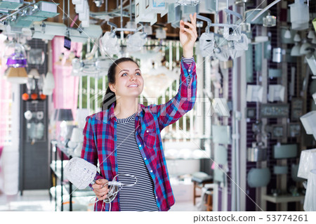 Woman choosing modern and stylish pendant lamp Woman choosing modern and stylish pendant lamp 53774261