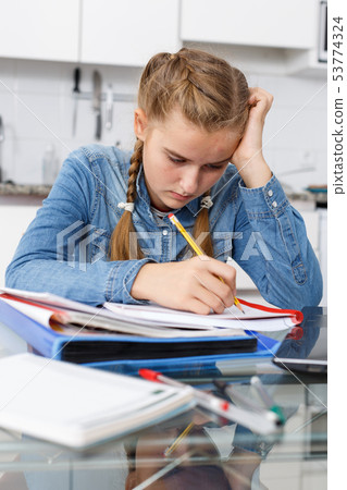 Girl tired of doing her homework Girl tired of doing her homework 53774324