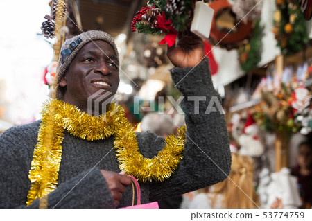 Man selecting festive Christmas decoration 53774759