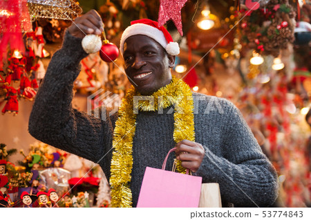 Man in Santa hat looking for New Year decorations 53774843