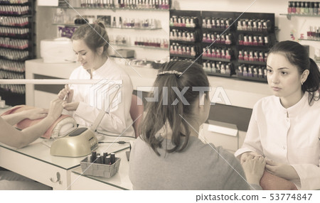 nail technicians performing manicure procedure in beauty salon 53774847