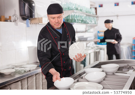Man preparing plates for setting Man preparing plates for setting 53774950