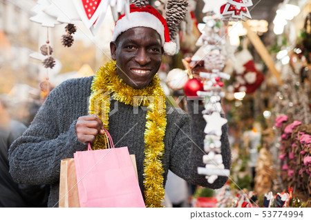 Laughing guy in Santa hat after Christmas shopping 53774994