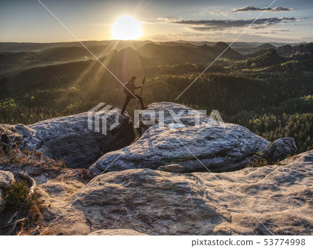 Photographer on mountain above valley with morning Photographer on mountain above valley with morning 53774998