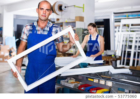 Portrait of experienced male worker with plastic window frame Portrait of experienced male worker with plastic window frame 53775060