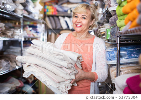 customer female choosing cotton tablecloths in the textile store customer female choosing cotton tablecloths in the textile store 53775304
