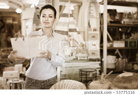 Woman standing with wooden box in decoration and furniture store Woman standing with wooden box in decoration and furniture store 53775316