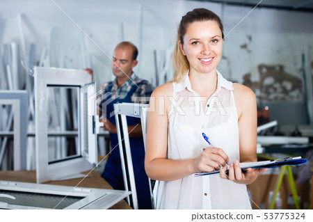 Woman manager standing with clipboard in workshop Woman manager standing with clipboard in workshop 53775324