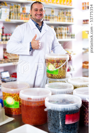 Male staff standing near containers with olives 53775354
