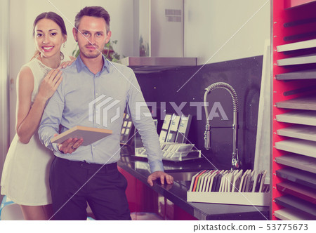 smiling married couple selecting kitchen furniture 53775673