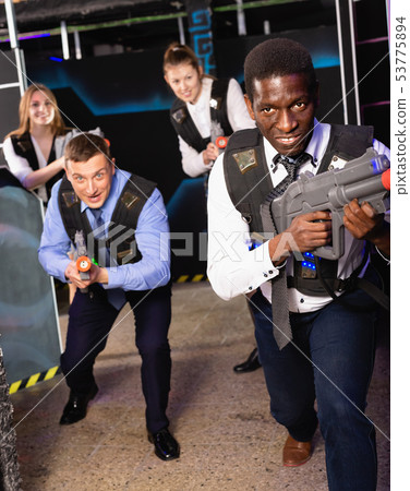 Group of colleagues holding laser pistols playing laser tag game 53775894