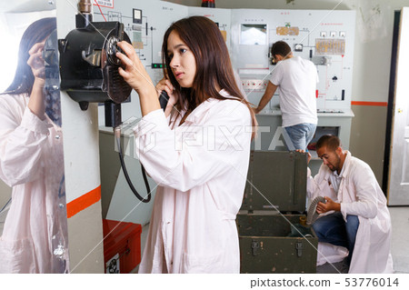Girl talking on old telephone in quest room 53776014