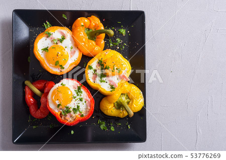Baked pepper stuffed with bacon and eggs Baked pepper stuffed with bacon and eggs 53776269