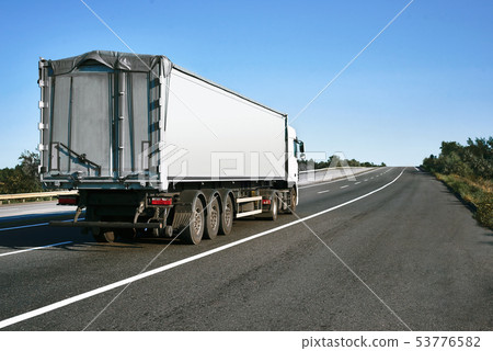 The truck is going up the road. Cargo The truck is going up the road. Cargo 53776582
