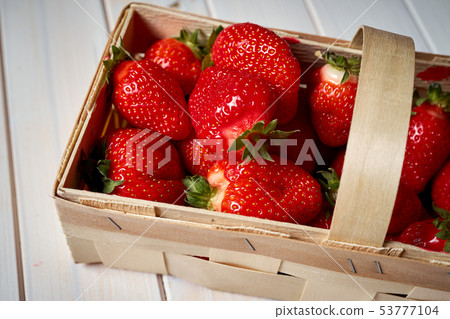 fresh juicy red strawberries in basket on white  table 53777104