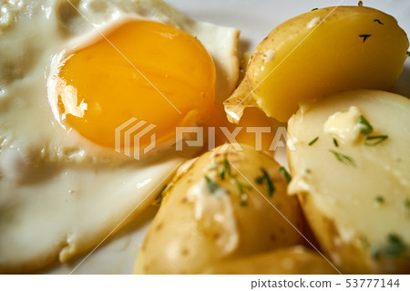 close up on fried eggs with young potatoes with butter and dill 53777144