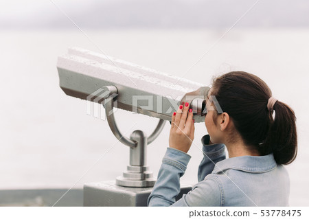 tourist looking through coin operated binoculars 53778475