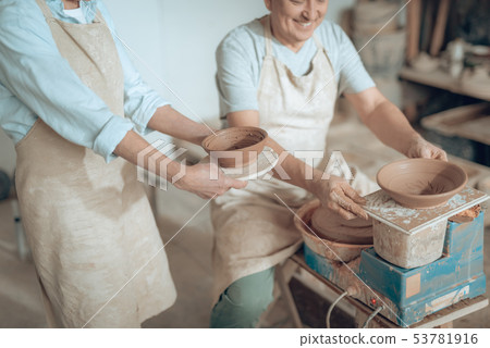 High angle of two potters showing their works in potter's studio 53781916