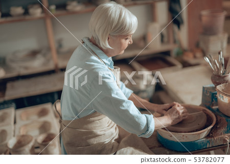 Cropped photo of mature craftswoman making decorative earthenware in potter's studio 53782077