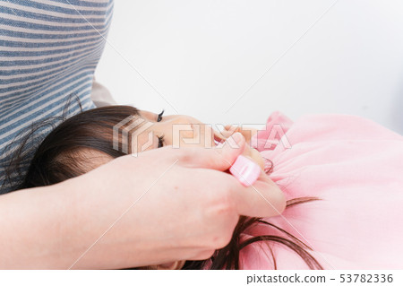 Mother brushing a child's teeth Mother brushing a child's teeth 53782336