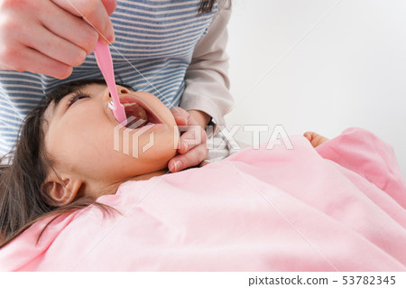 Mother brushing a child's teeth Mother brushing a child's teeth 53782345