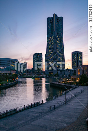 橫濱港未來區的日落：地標塔和運河沐浴在暮色之中。 53782416
