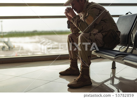 Low angle of American soldier in camouflage praying indoors 53782859