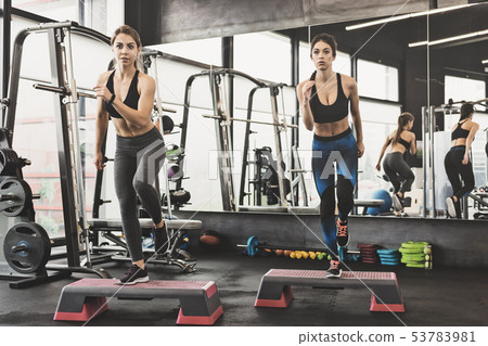 Sportive women making step aerobics Sportive women making step aerobics 53783981