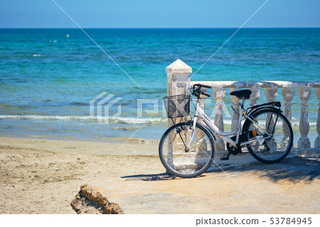 Bicycle leaned to balustrade near sea 53784945