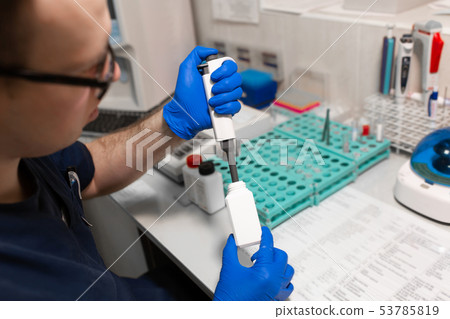laboratory assistant analyzing a blood sample laboratory assistant analyzing a blood sample 53785819