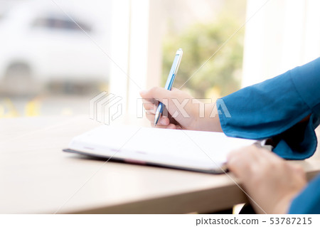 Closeup hand woman writer thinking and writing Closeup hand woman writer thinking and writing 53787215