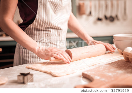 Young female person holding rolling pin in hands Young female person holding rolling pin in hands 53791929