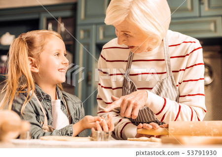 Positive delighted girl listening to her granny Positive delighted girl listening to her granny 53791930