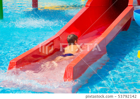 Happy cheerful caucasian boy on water slide at Happy cheerful caucasian boy on water slide at 53792142