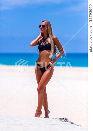 Model in black swimsuit posing at the beach 53793649