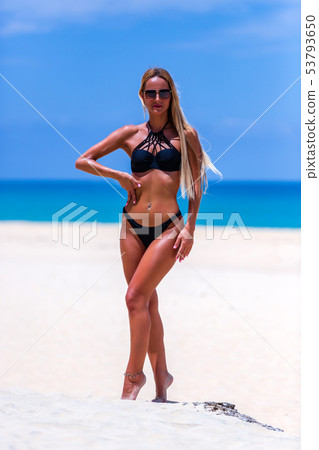 Model in black swimsuit posing at the beach 53793650