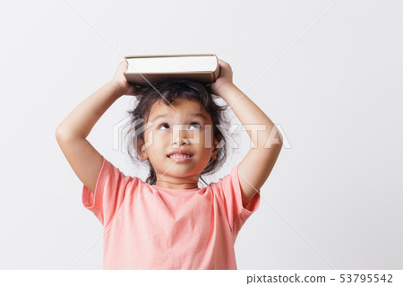 Asian little girl holding a book on head  53795542