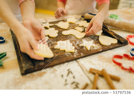 Little girls chefs spread out cookies on board 53797536