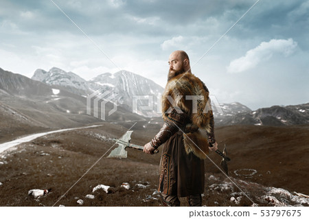Viking with axes in hands at the rocky mountains 53797675