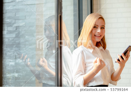 Young businesswoman standing near the office Young businesswoman standing near the office 53799164