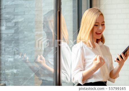 Young businesswoman standing near the office Young businesswoman standing near the office 53799165
