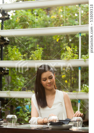 Woman white short dress sit in Herb restaurant Woman white short dress sit in Herb restaurant 53809318