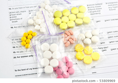 Pink, white and yellow pills in plastic bags Pink, white and yellow pills in plastic bags 53809969